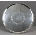 A George III silver circular salver with raised beaded edge, engraved foliate scroll decoration &