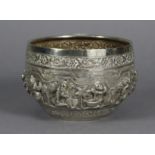 A Burmese white metal circular deep bowl with continuous band of repousse decoration depicting