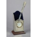 A modern silver desk card holder of upright oblong form, inset quartz timepiece & on wooden base,