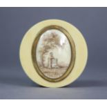 A 19th century ivory snuff box of circular shape, inset oval en-grisaille memento scene in brass