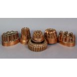Six Victorian copper jelly moulds of varying designs.