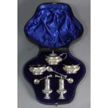 An Edwardian silver condiment set comprising a pair of oval lobed salt cellars & matching mustard