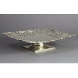 A George VI silver large square comport with finely pierced, engraved & cast grapevine border, on