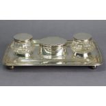A George V silver large desk inkstand of rectangular shape with raised moulded rim, a pen trough