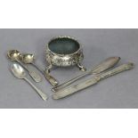 A George II silver circular salt cellar with chased floral decoration & on three pad feet, London