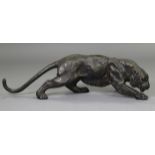 A 20th century BRONZE LARGE MODEL OF A PANTHER, with incised features & patinated finish; 42.5” long