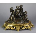 A 19th century patinated bronze model of putti engaged in various activities, on a rocky base, &