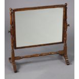 A mahogany skeleton-frame swing toilet mirror with ring-turned supports & shaped feet, 22¾” wide x