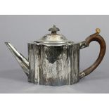 A George III provincial silver teapot of straight-sided oval form & serpentine outline, with domed