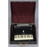 A Settimo Sporani piano accordion in black polished case, & with fibre-covered travelling case.