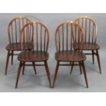 A set of four Ercol spindle-back dining chairs with hard seats, & on round tapered legs with spindle