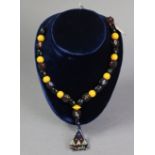 A bead necklace strung with alternating yellow & black coloured beads, having triangular beadwork