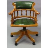A beech swivel desk chair with padded seat & back upholstered green leatherette.