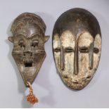 A Lega Bwami three-face mask, 10.5" & another mask with protuding eyes & long pointed chin, 9.25".