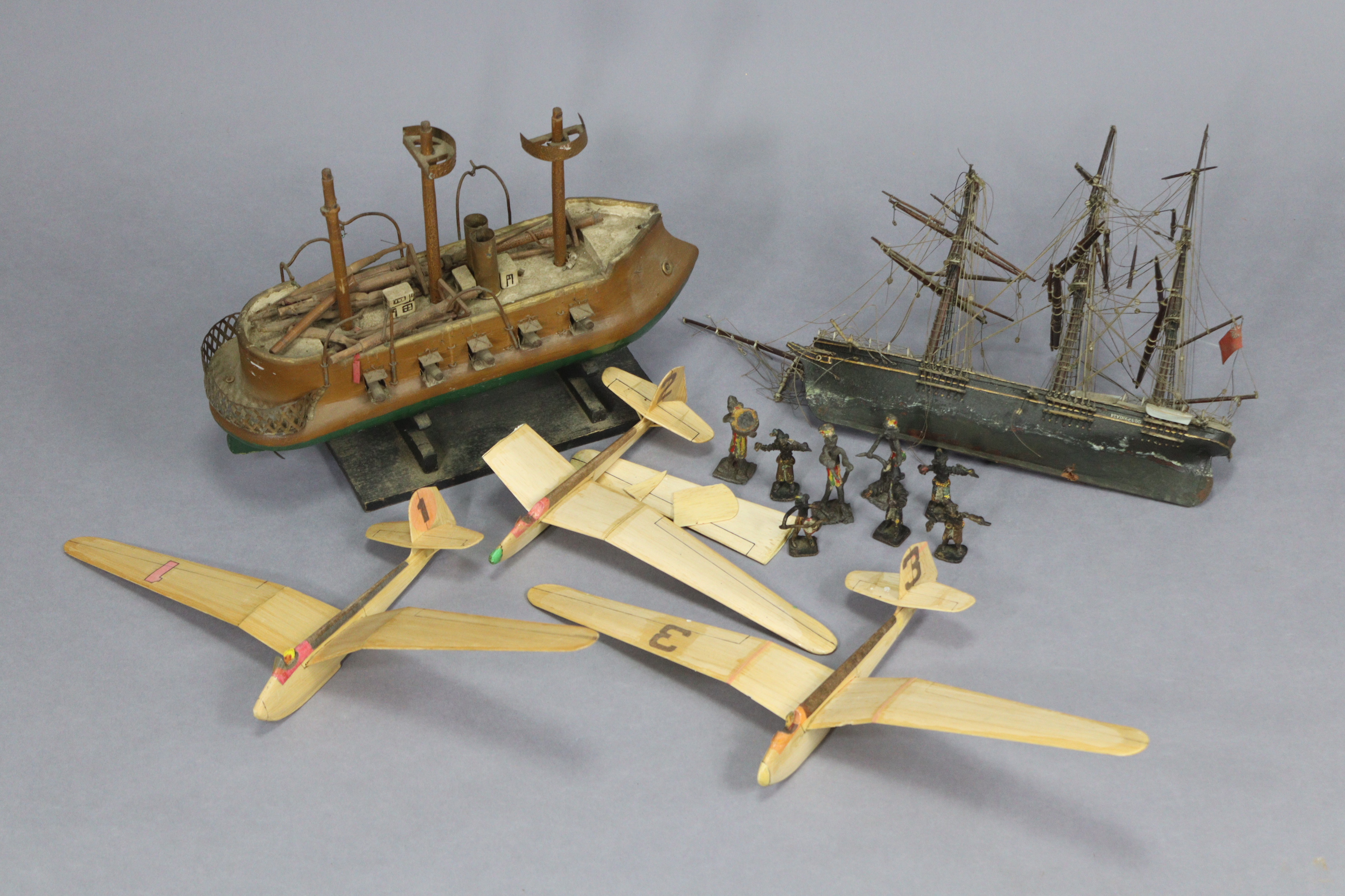Eight painted lead African bandsmen figures; together with two wooden model ships; & three balsa