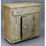 A pine cabinet fitted with a frieze drawer above cupboard enclosed by a centre panel door, & on