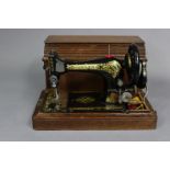 A vintage Singer hand sewing machine with oak case.
