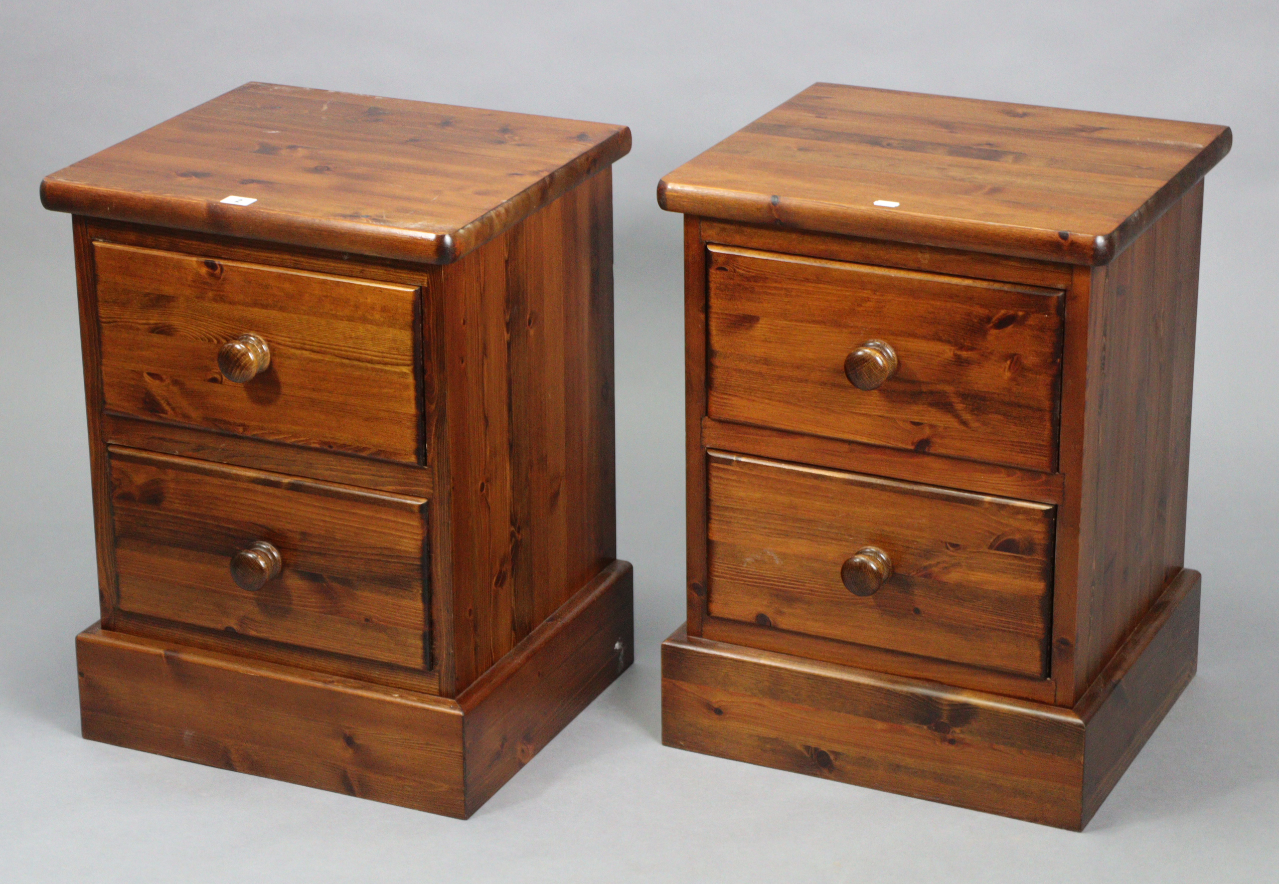 A pair of pine two-drawer bedside chests, 18¾” wide x 25” high x 16¾” deep.