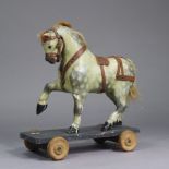 A VINTAGE DAPPLE-GREY PAINTED WOODEN PULL-ALONG HORSE, 18” wide x 19” high.