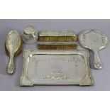 An Edwardian silver five-piece dressing table set comprising a rectangular tray, 11¾” x 8¼”, a