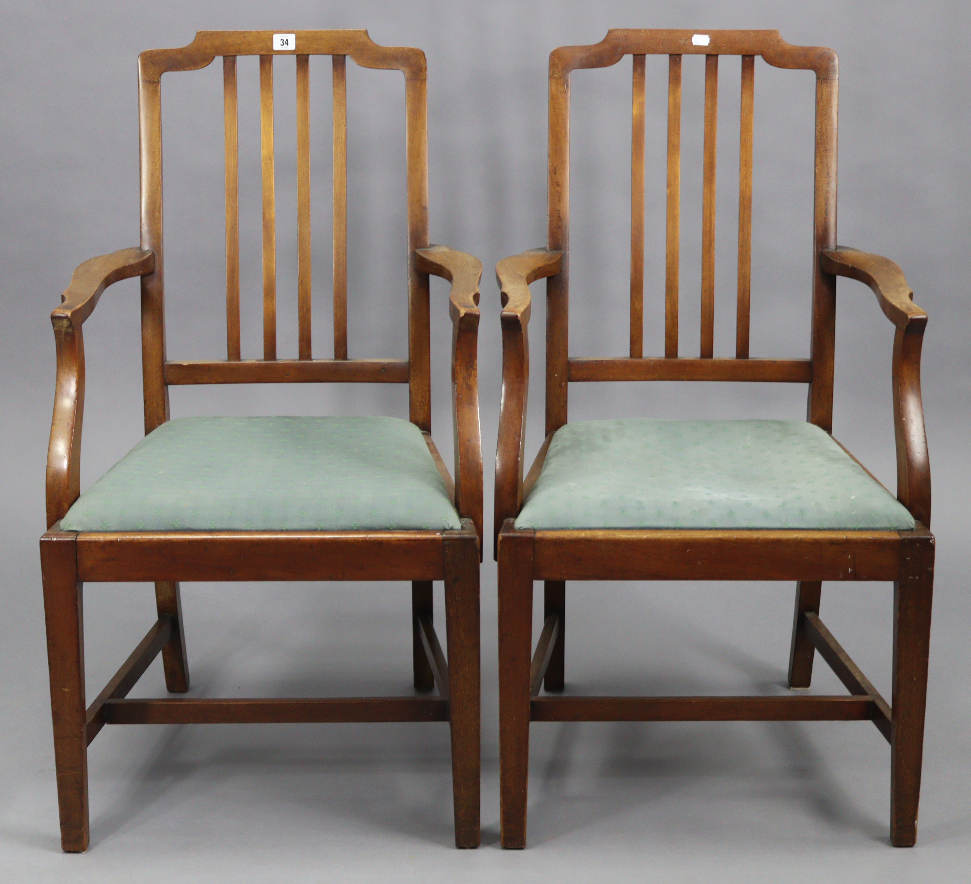 A pair of Edwardian mahogany rail-back elbow dining chairs, with padded drop-in seats & on square