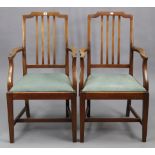 A pair of Edwardian mahogany rail-back elbow dining chairs, with padded drop-in seats & on square