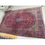 A Persian rug, decorated with a central motif, profusely bordered by floral and foliate ornament,