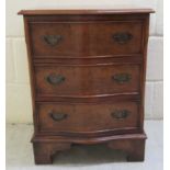 A mid 20thC burr walnut veneered serpentine front, three drawer bedside chest,