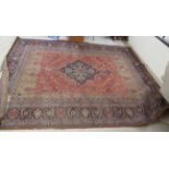 A Persian carpet, decorated with a central serpentine, diamond shaped motif,