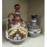 A Royal Doulton brown, green and blue glazed stoneware decanter of bulbous form,