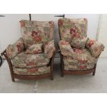 A pair of modern Ercol elm framed easy chairs with cushioned fabric upholstered backs and seats,