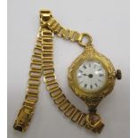 An 18ct gold cased lady's fob watch, adapted to a wristwatch, on a later yellow metal strap,