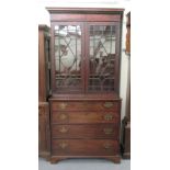 A George III mahogany cabinet bookcase, having a dentil moulded cornice,