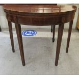 A Regency satinwood and ebony inlaid mahogany demi-lune card table with a foldover top,