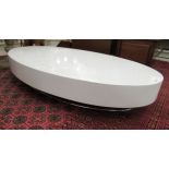 A modern white laminate oval coffee table,