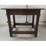 A George III stained oak single drawer side table, raised on block legs,