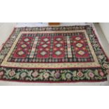 A Caucasian carpet, decorated with repeating diamond formation and stylised floral designs,
