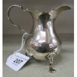 A George II silver cream jug of bulbous form with a decoratively cut,