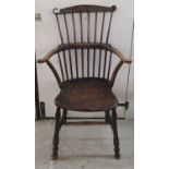 A late 19th/early 20thC elm and beech framed, spindled comb back arm chair,