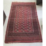 A Bokhara rug with three columns of twelve guls, bordered by stylised designs,