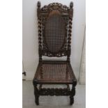 An early 20thC carved oak hall chair with a caned back and seat,