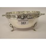 A silver dish with a bead bordered and uniformly pierced upstand rim and opposing bar handles,