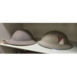Two similar World War II British 'tin hats' with liners (Please Note: this lot is offered subject