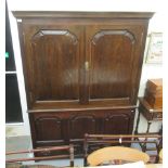 An 18thC and later oak cabinet with a moulded cornice, over two panelled doors,