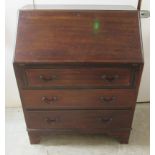 An early 20thC string inlaid mahogany bureau, the fall flap over three long drawers,