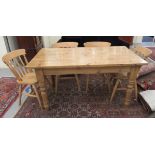 A modern stained pine farmhouse dining table, raised on turned,