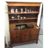 A George III oak dresser, the superstructure with three open shelves and two drawers,