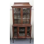 An Edwardian string inlaid and crossbanded mahogany display cabinet with a shaped cornice,