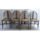 A set of four Ercol beech framed, hoop and spindled pierced splat back chairs,