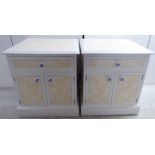 A pair of modern white painted bedside chests with a single drawer, over two cupboard doors,